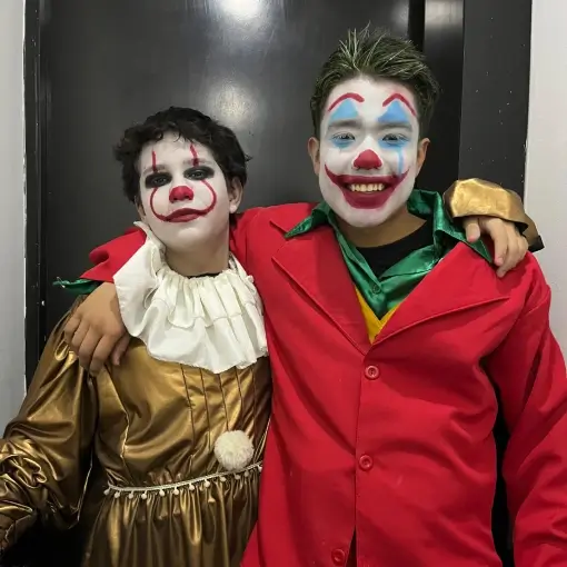 dos niños celebran escapar de una sala de escape disfrazados joker y payaso it